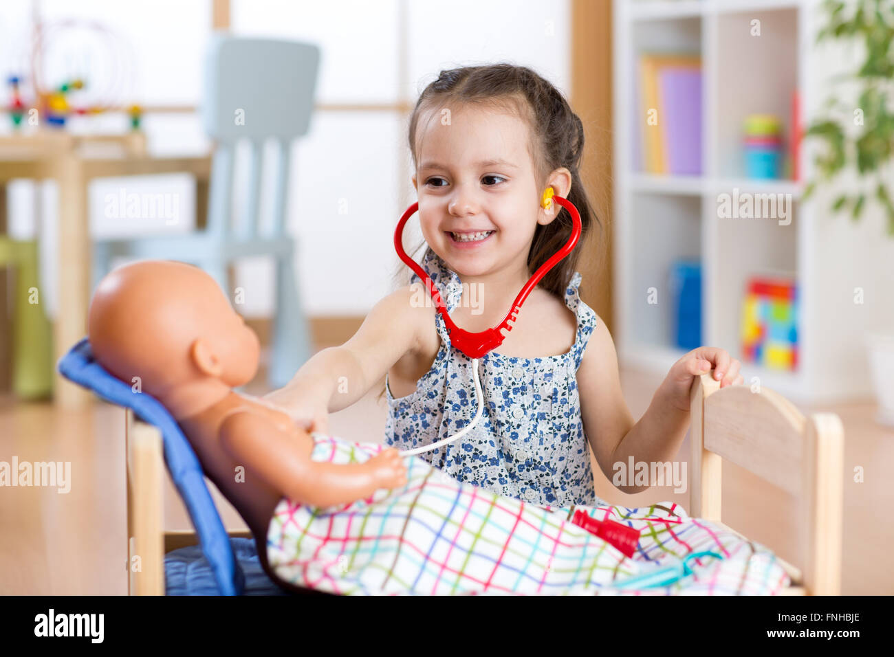 Bambino che gioca medico con il giocattolo a casa Foto Stock