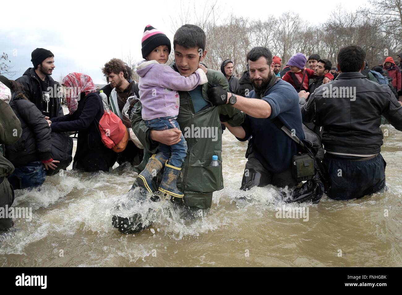 Idomeni, Grecia. Il 14 marzo 2016. Migliaia di migranti bloccati nel campo di Idomeni decidere di attraversare la frontiera macedone alla fine della recinzione di filo,a camminare per ore e attraversando il fiume con acqua molto fredda aiutato da volontari.tre rifugiati annegato attraversando il fiume.decine di giornalisti e volontari arrestati dalla polizia macedone nel pomeriggio per ingresso illegale. Photo credit: Danilo Balducci/Sintesi/Alamy Live News Foto Stock