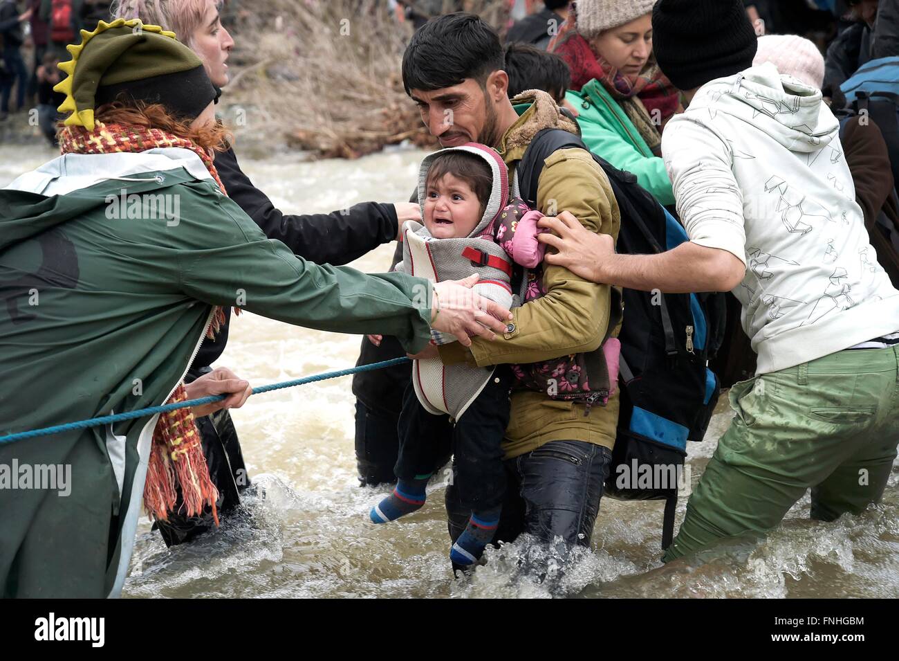 Idomeni, Grecia. Il 14 marzo 2016. Migliaia di migranti bloccati nel campo di Idomeni decidere di attraversare la frontiera macedone alla fine della recinzione di filo,a camminare per ore e attraversando il fiume con acqua molto fredda aiutato da volontari.tre rifugiati annegato attraversando il fiume.decine di giornalisti e volontari arrestati dalla polizia macedone nel pomeriggio per ingresso illegale. Photo credit: Danilo Balducci/Sintesi/Alamy Live News Foto Stock