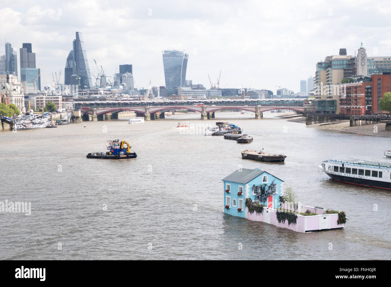 Una singola casa famiglia galleggiando giù il fiume Tamigi nel centro di Londra Foto Stock