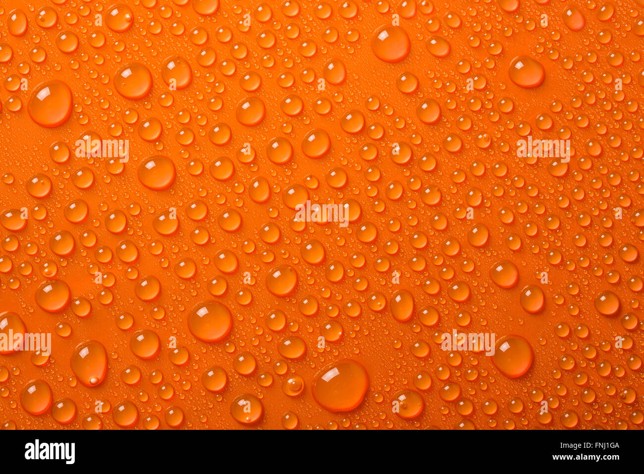 Gocce di acqua su sfondo arancione Foto Stock