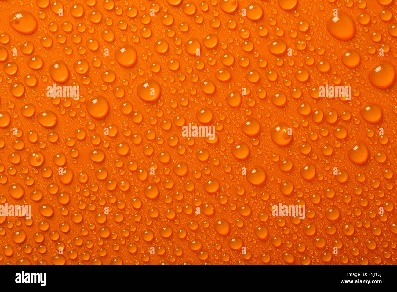 Gocce di acqua su sfondo arancione Foto Stock