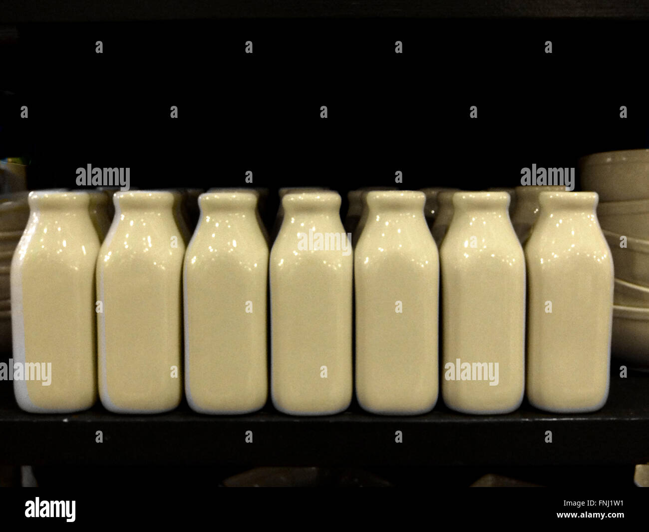 Bianco piccoli contenitori in ceramica a forma di vecchio stile bottiglie di latte. Al Fishs Eddy su Broadway in Manhattan inferiore, NYC Foto Stock