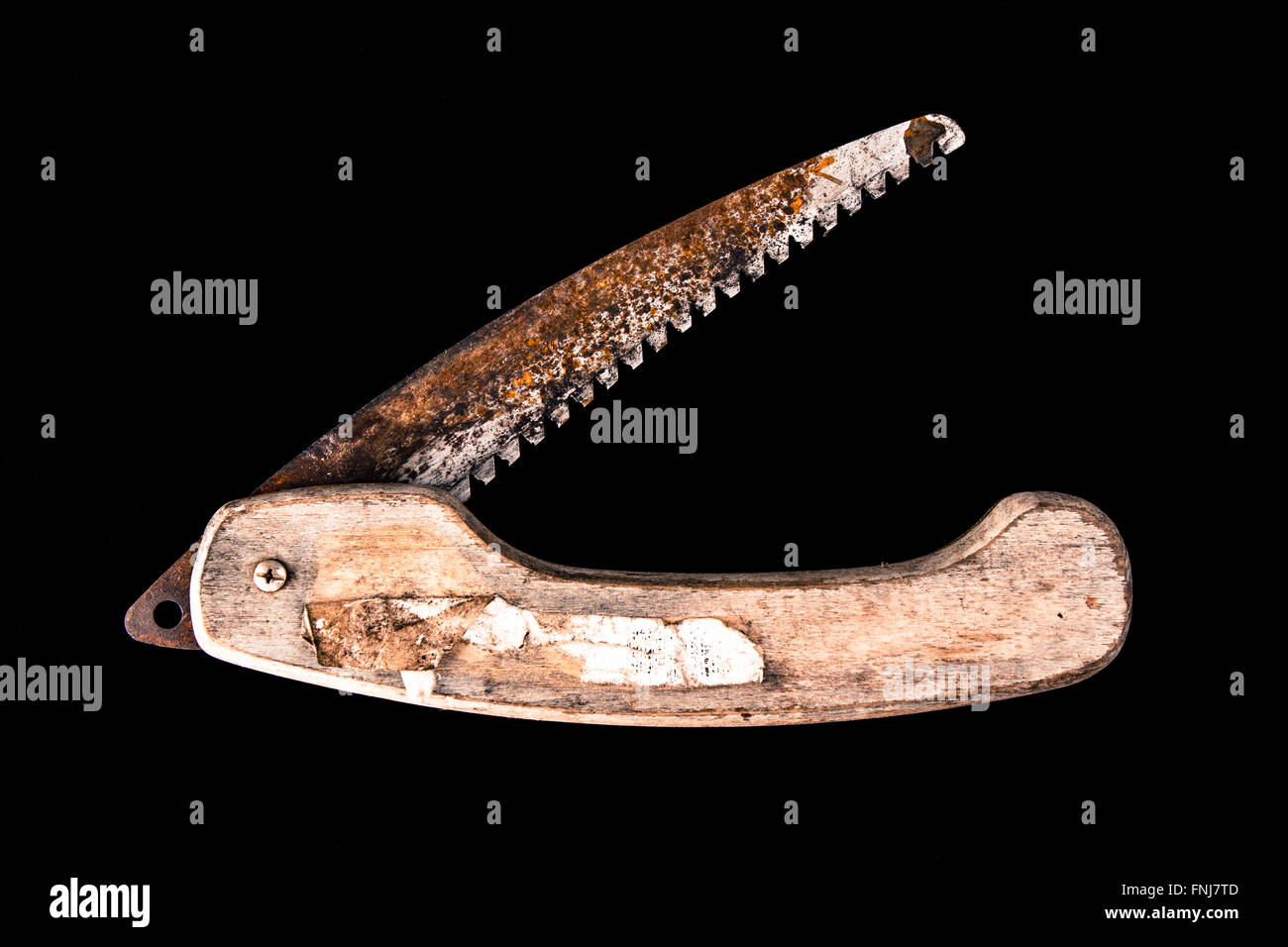 Rusty piegatura sega potatura con un manico di legno aperto e isolate su uno sfondo nero Foto Stock