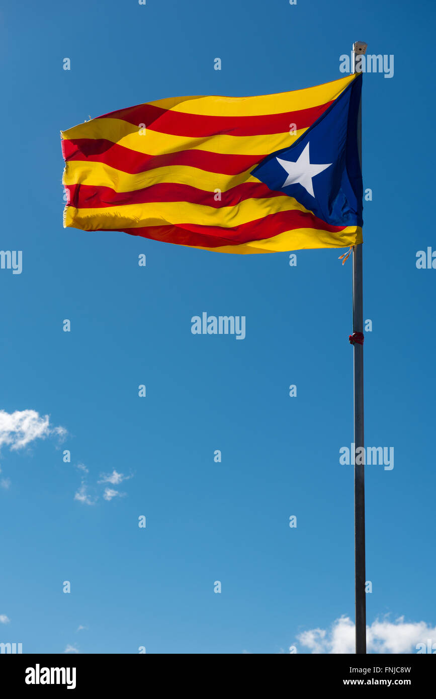 Sventola bandiera della Catalogna (estelada blu) oltre il cielo blu sullo sfondo Foto Stock