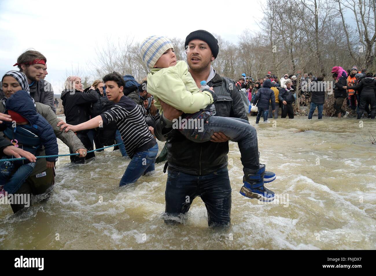 Idomeni, Grecia. Il 14 marzo 2016. Migliaia di migranti bloccati nel campo di Idomeni decidere di attraversare la frontiera macedone alla fine della recinzione di filo,a camminare per ore e attraversando il fiume con acqua molto fredda aiutato da volontari.tre rifugiati annegato attraversando il fiume.decine di giornalisti e volontari arrestati dalla polizia macedone nel pomeriggio per ingresso illegale. Photo credit: Danilo Balducci/Sintesi/Alamy Live News Foto Stock