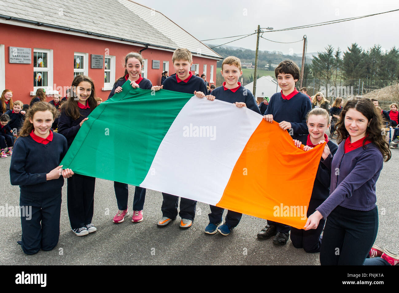 Durrus, Irlanda. Il 15 marzo, 2016. Gli alunni Cahernane Stock; Niamh Bignall; Rebecca Harrington; Luca Daly; James Padre Mallon ha; Eoin Stock; Erica Ross e Jessica O'Driscoll visualizzare il tricolore irlandese prima del sollevamento della bandiera in Carrigboy Scuola nazionale, Durrus, sulla proclamazione giorno che era stata organizzata per commemorare gli eventi del 1916. Credito: Andy Gibson/Alamy Live News. Foto Stock