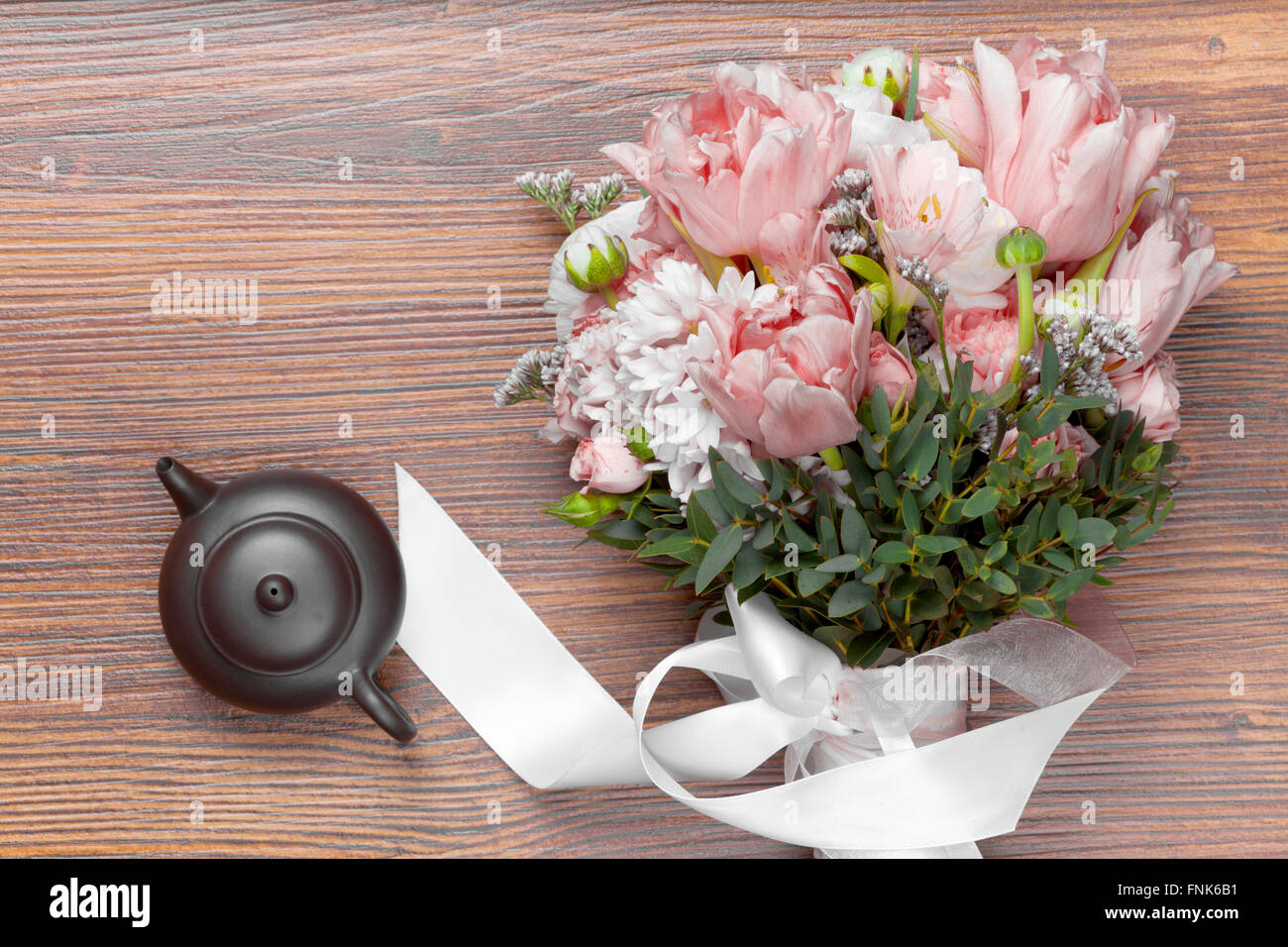 Sorprendente bouquet di fiori con ceramiche tè pentola su sfondo di legno Foto Stock
