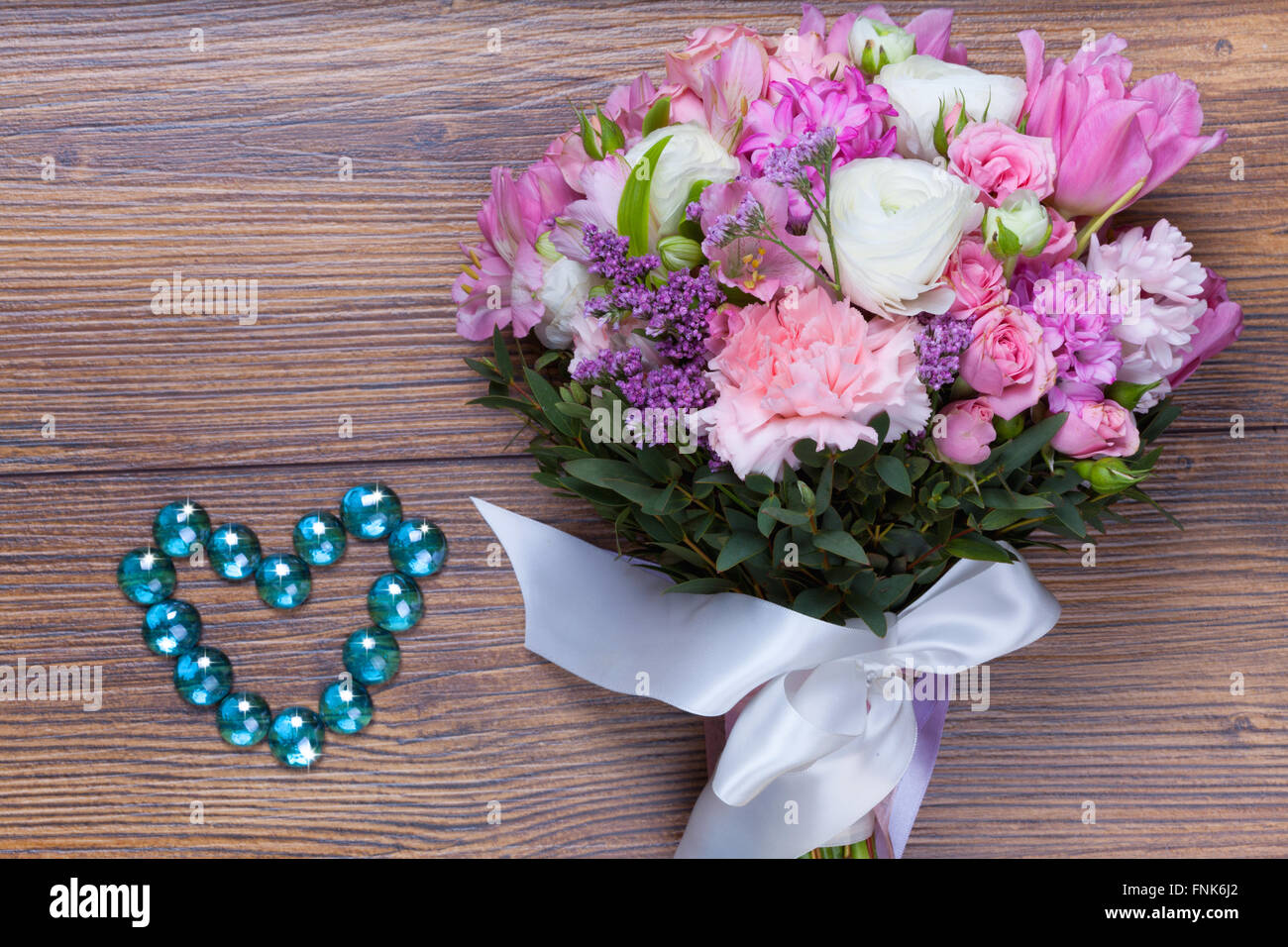 Fiori di San Valentino con heartshaped gioielli su sfondo di legno Foto Stock