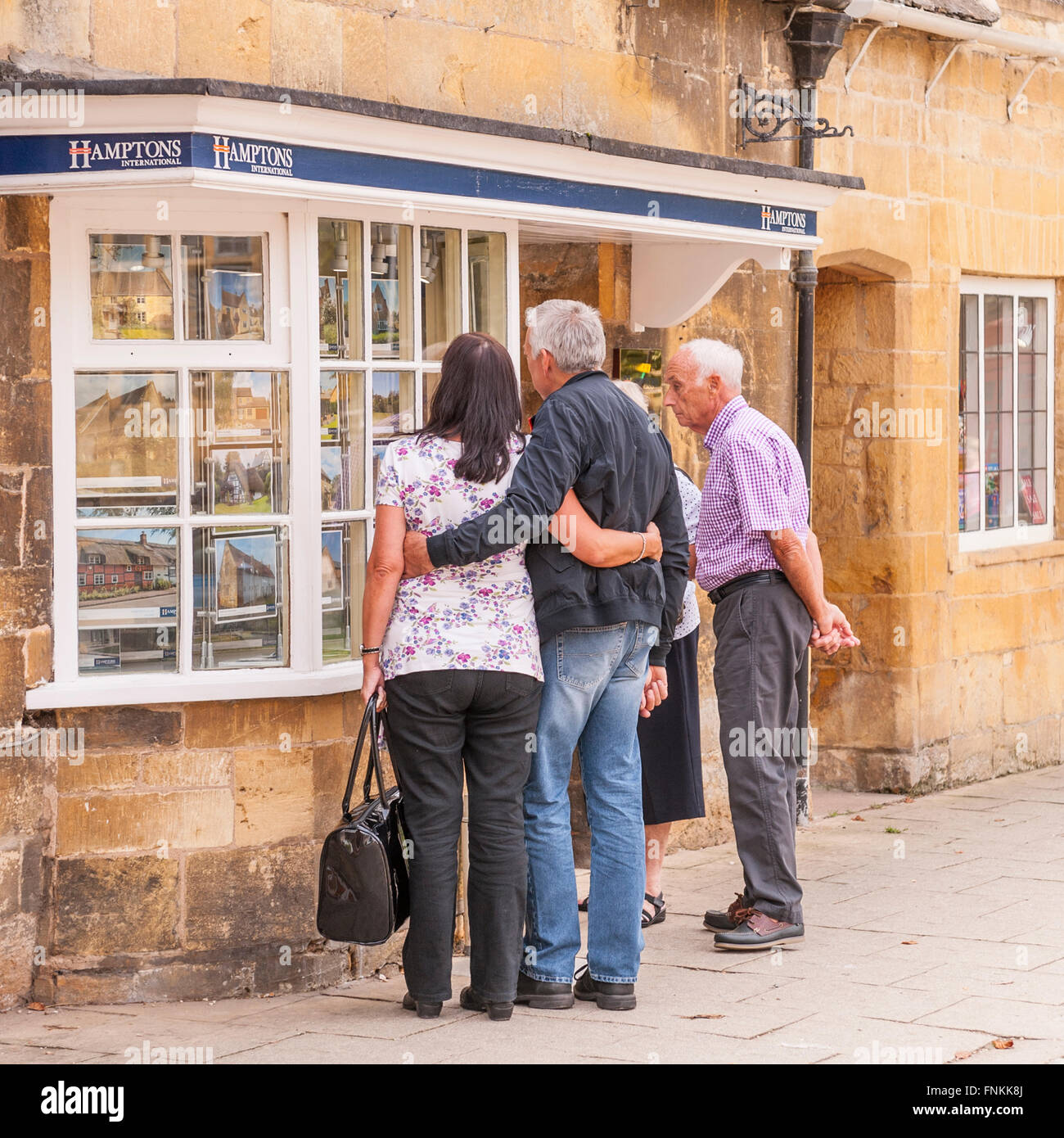 Le persone in cerca di un Agenti Immobiliari finestra in Broadway , Worcestershire , Inghilterra , Inghilterra , Regno Unito Foto Stock