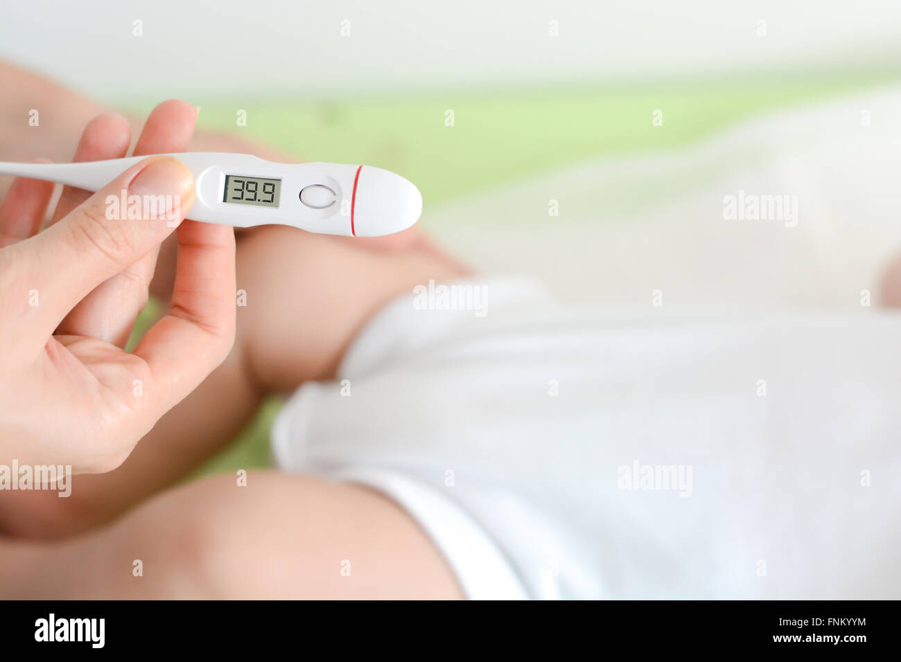 Controllare la temperatura del bambino che indica la febbre alta sul termometro Foto Stock