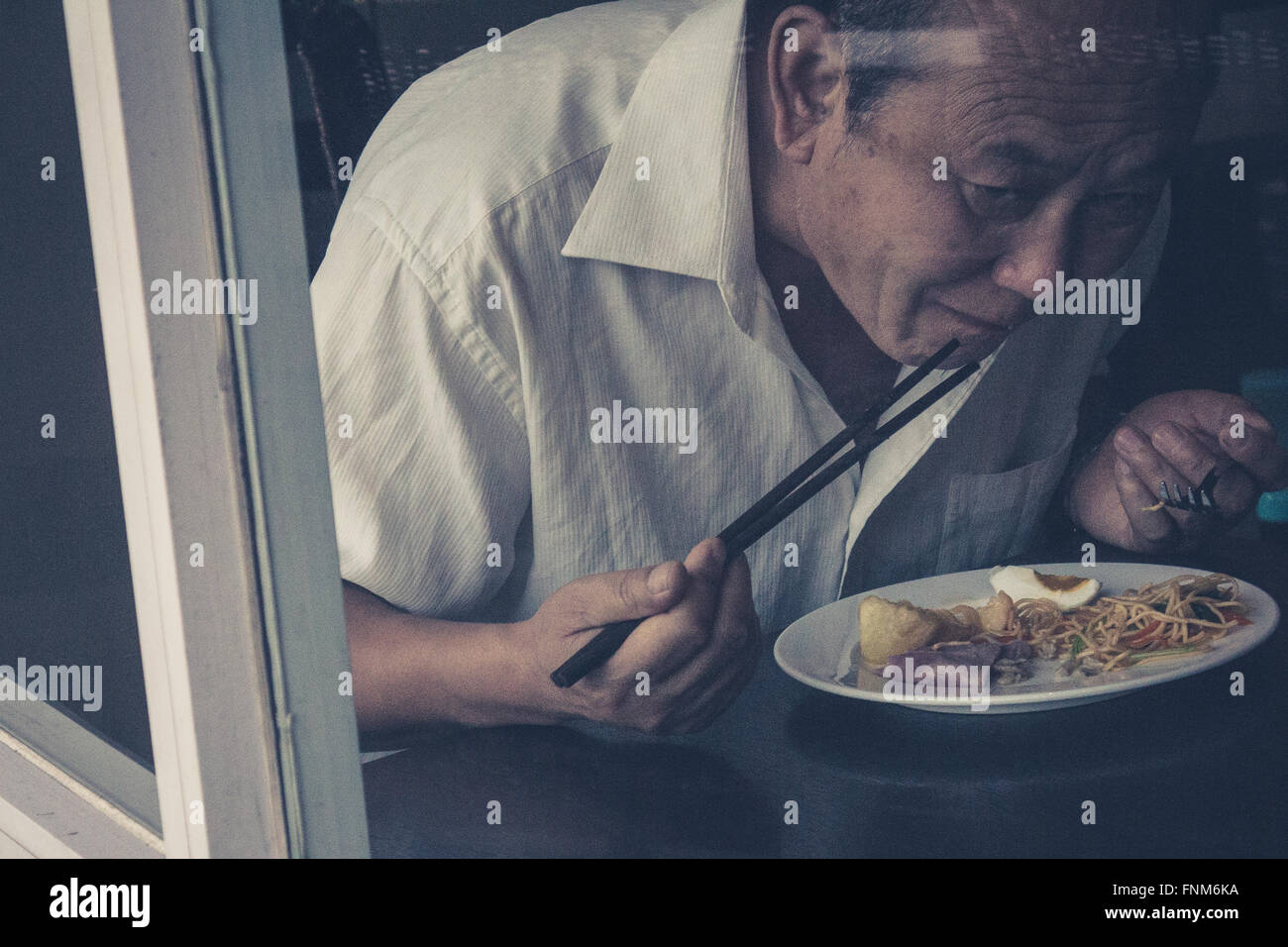 Ritratto di un vecchio uomo asiatico mangiare Foto Stock