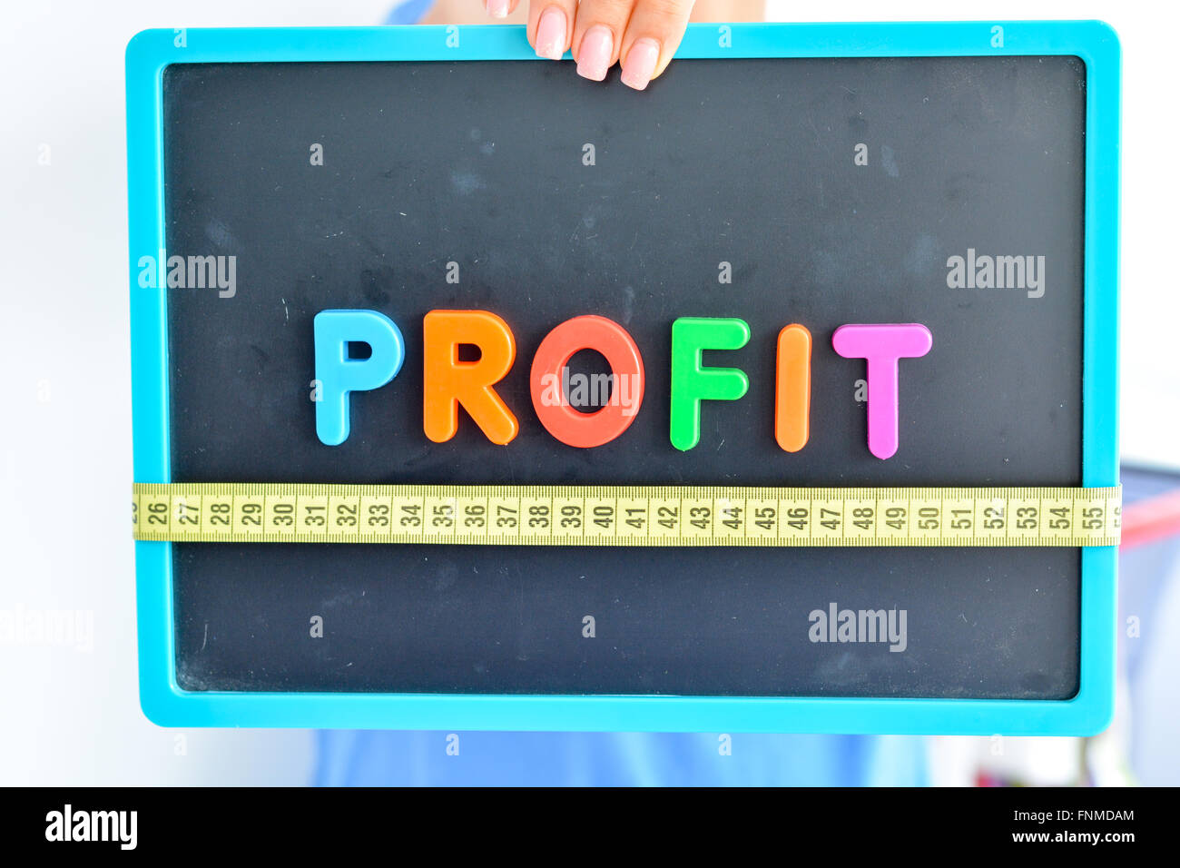 Misurare il concetto di profitto scritto come colorato magnetico lettera blocchi con scala Foto Stock