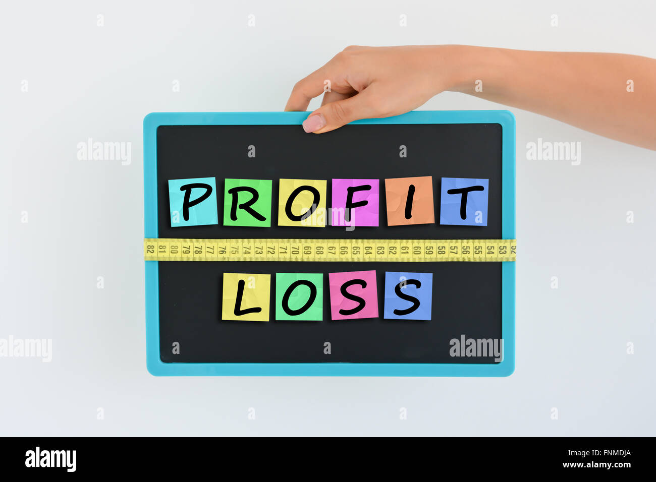 Misurare il concetto di profitto scritto come colorato magnetico lettera blocchi con scala Foto Stock