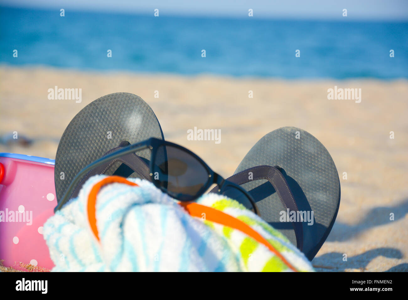 Spiaggia accessori come occhiali da sole, pantofole, asciugamano, giocattoli sulla sabbia Foto Stock