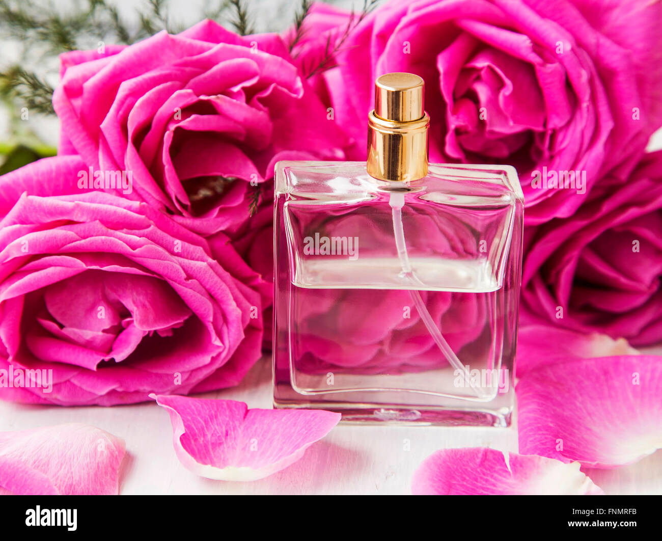 Profumo di rose in bottiglia trasparente con le rose rosa fiori Foto Stock