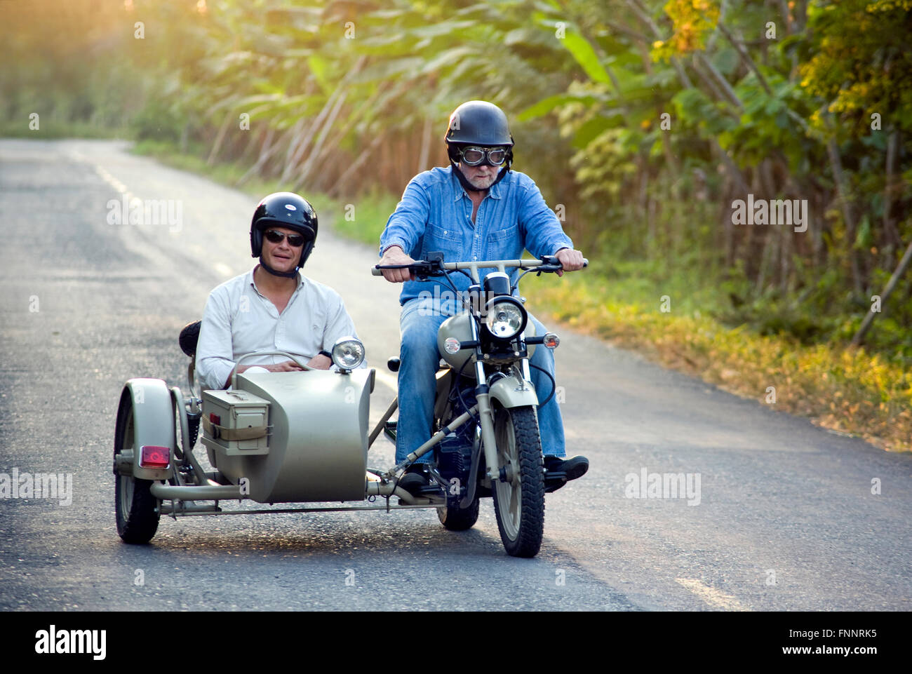 Presidente Rafael Correa e show host Peter Greenberg guidare una motocicletta vintage con un sidecar nel cacao regione durante le riprese di Ecuador: Royal Tour. Foto Stock