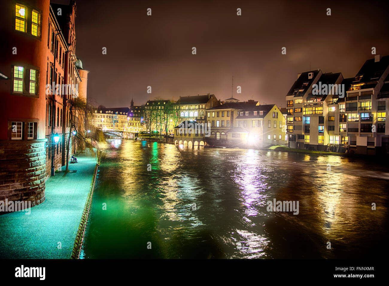 Vista panoramica vista sul fiume a Strasburgo, in Francia durante la notte. Romantiche luci riflettendo sull'acqua e case tradizionali e bui Foto Stock