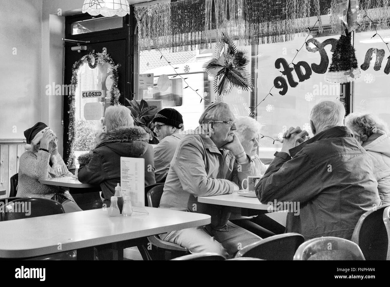 I cittadini anziani pernsioners, prendere il pranzo e chat, nel tempo di Natale in un pesce e chip shop a Whitby, Yorks, REGNO UNITO Foto Stock