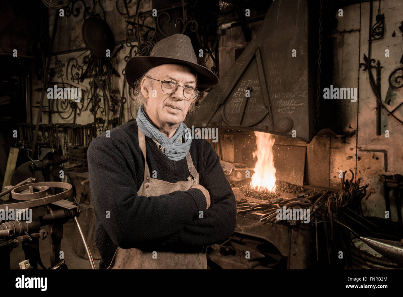 Ironworker forgiatura del ferro caldo in officina Foto Stock