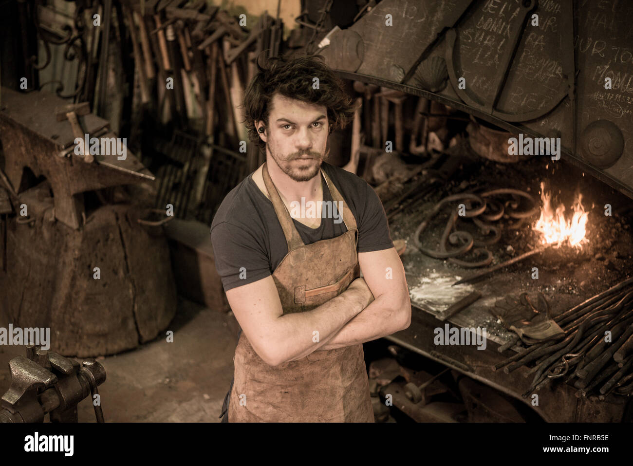 Ironworker forgiatura del ferro caldo in officina Foto Stock