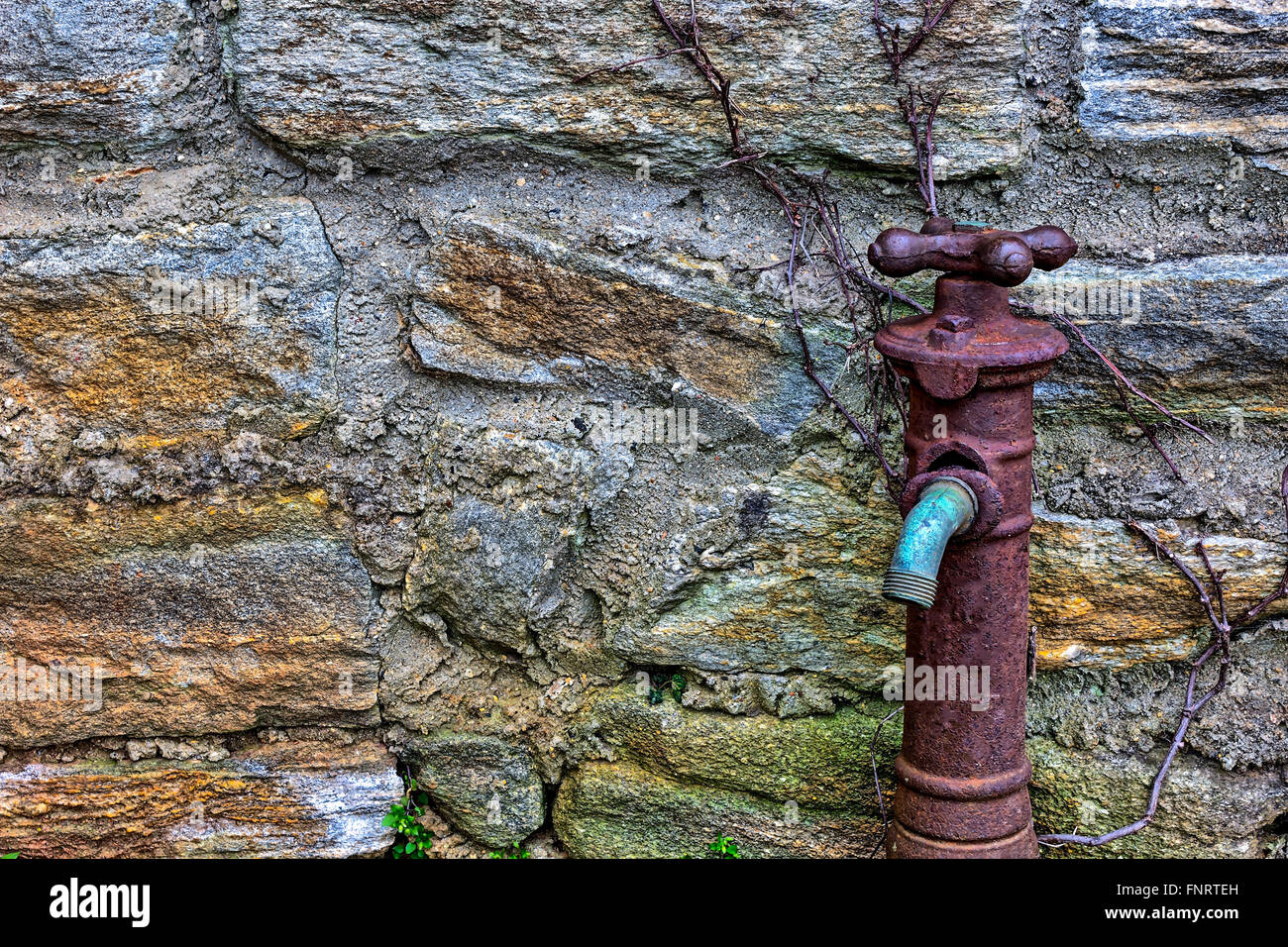 Vecchio arrugginito rubinetto di acqua sul lato dell'edificio Foto Stock