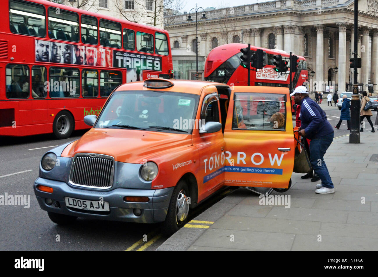 Londra, UK, 12 febbraio 2016, Black Cab preleva i passeggeri su sedia a rotelle al di fuori del National Portrait Gallery. Il conducente si alza dal Foto Stock