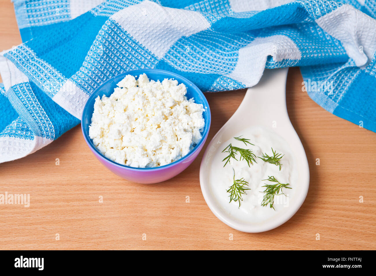 Per la ricotta in una ciotola accanto a un gran ciuffo di panna acida Foto Stock