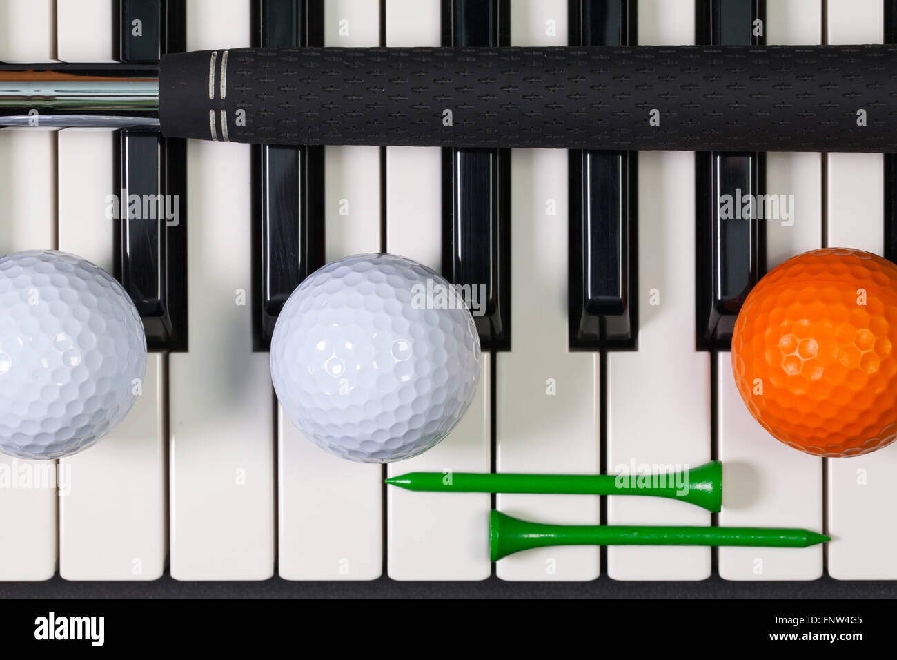 Virtuosi di gioco - Una tastiera di pianoforte e diverse attrezzature da golf Foto Stock