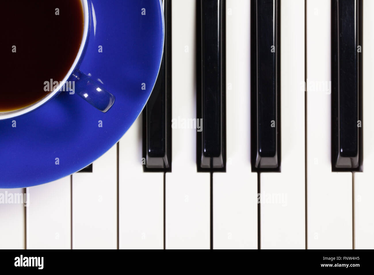 Dettaglio della tastiera di pianoforte e la tazza di caffè Foto Stock