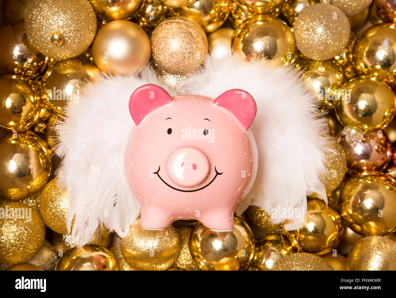Risparmio di denaro a Natale piggybank su oro baubles Foto Stock