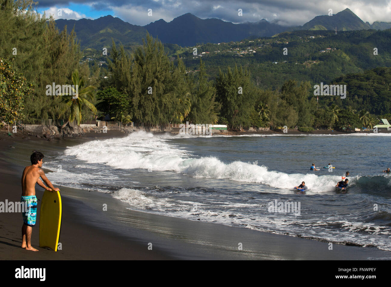 Surfers presso la spiaggia di sabbia nera sulla Pointe Venus, Tahiti, Polinesia Francese Tahiti Nui, Isole della Società, Polinesia francese, Sud Foto Stock