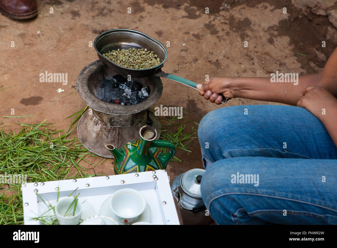 Una donna la tostatura i chicchi di caffè come parte di una cerimonia di caffè Etiopia rurale, Africa Foto Stock