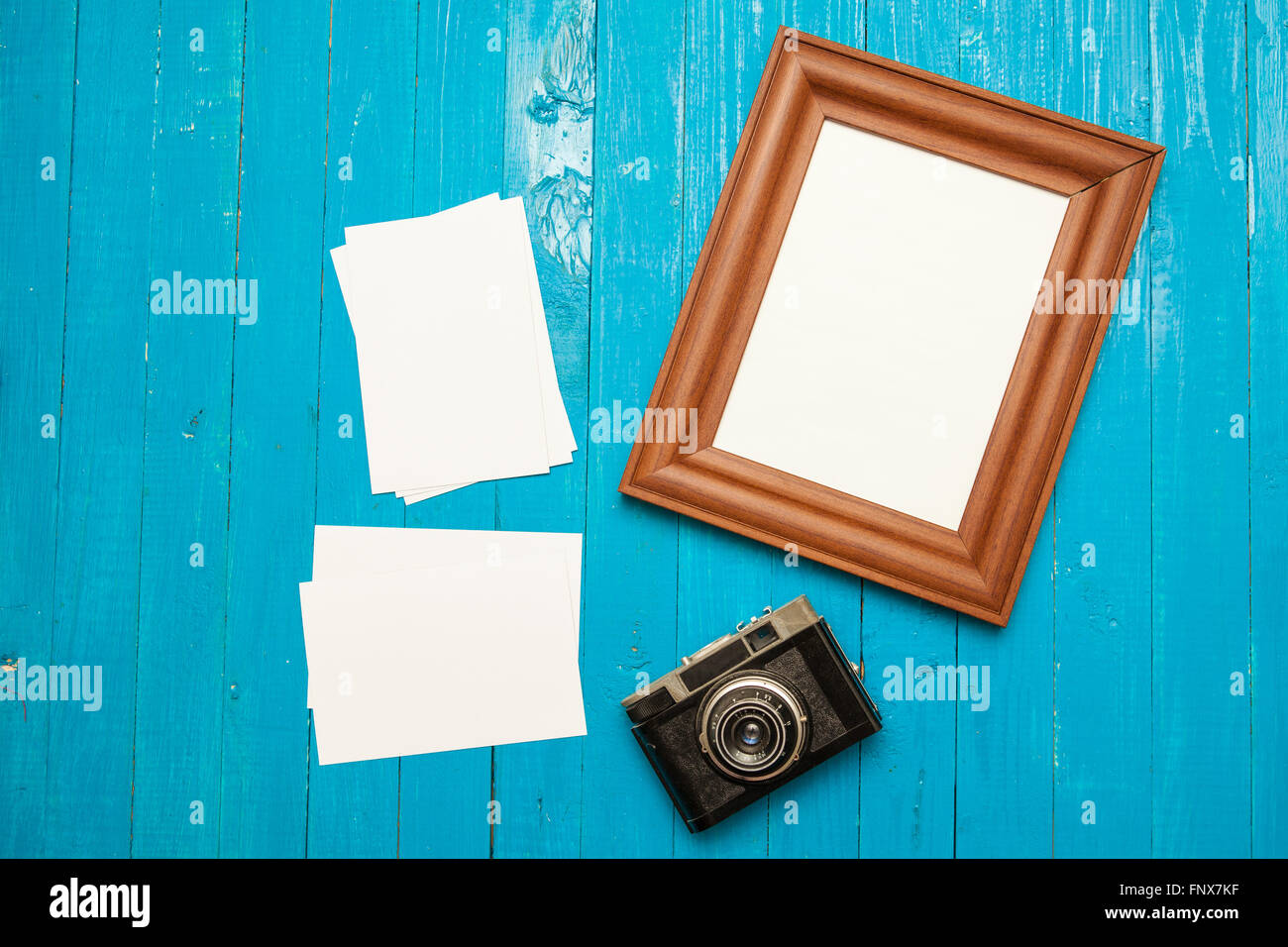 Fotocamera retrò, photo frame e foto su un blu sullo sfondo di legno Foto Stock