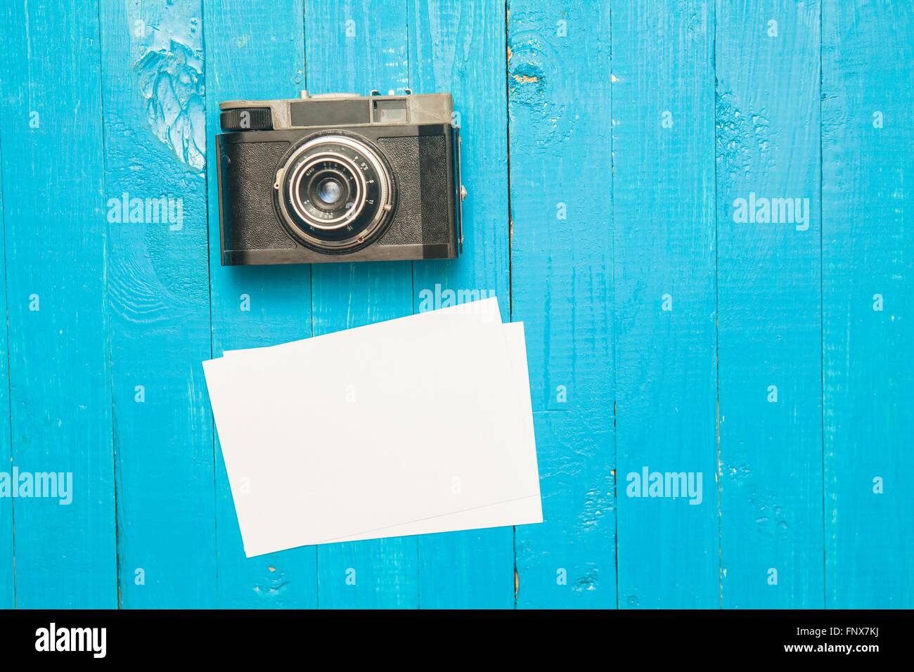 Fotocamera retrò, photo frame e foto su un blu sullo sfondo di legno Foto Stock