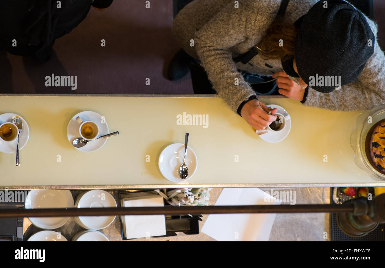 Donna cliente di bere il caffè espresso italiano al bancone bar in coffee shop Foto Stock