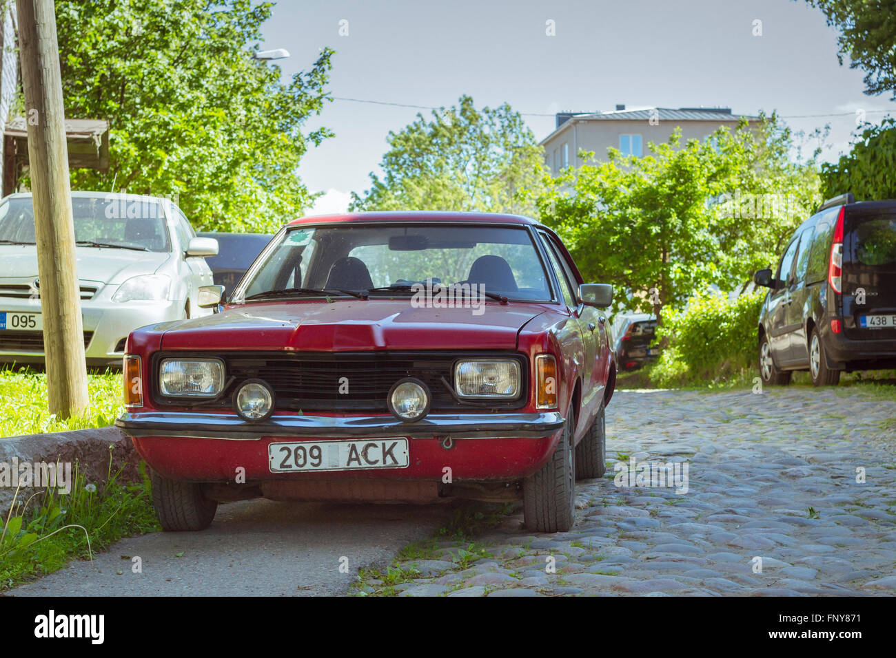 Tallinn, Estonia - Yuni 12, 2015: Rosso vecchia auto Ford Taunus parcheggiata sul marciapiede in una strada deserta. Soleggiata giornata estiva. Tallinn Foto Stock