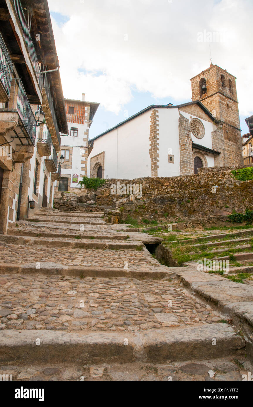 La chiesa e la strada di ciottoli. Candelario, provincia di Salamanca, Castilla Leon, Spagna. Foto Stock