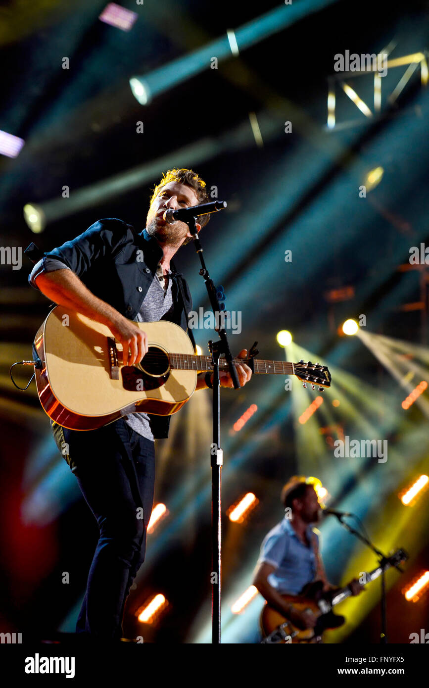 Musicisti sul palco a suonare la chitarra con un sacco di illuminazione del palcoscenico Foto Stock