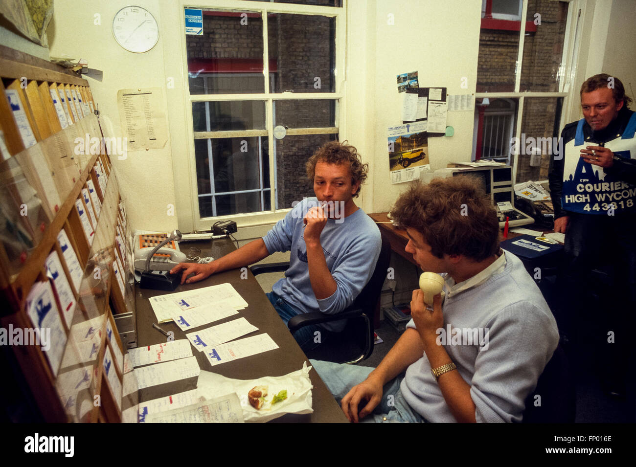 Motociclo corriere dispatch office nel centro di Londra nel 1986. Scansione da 35mm pellicola di scorrimento. Foto Stock