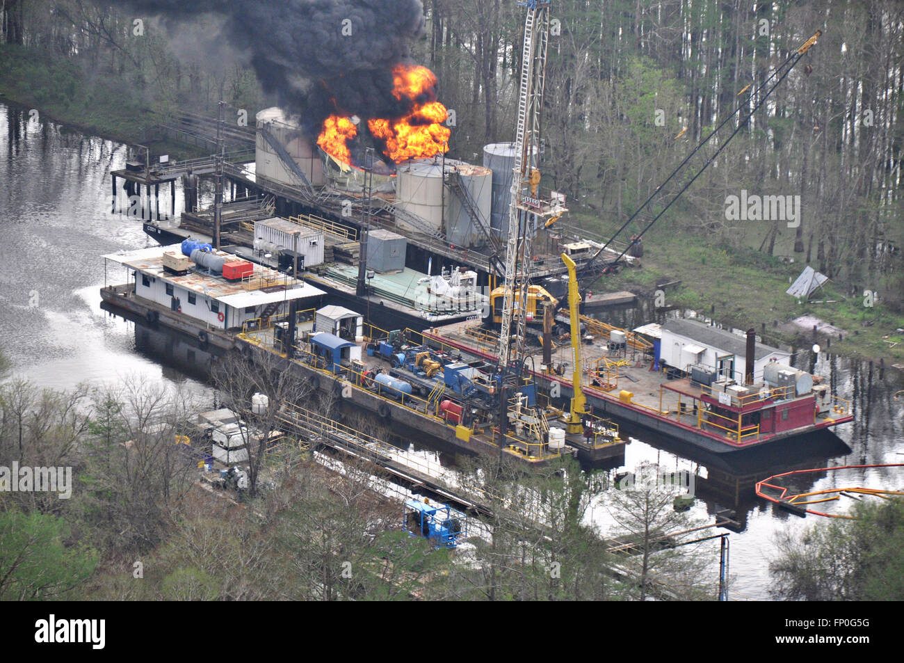 Vista aerea del fuoco sul Lago di bacche olio piattaforma di produzione nel profondo di una palude Marzo 15, 2016 in Bayou Sorrel, Louisiana. La piattaforma ha preso fuoco mentre era in fase di smontaggio. Foto Stock