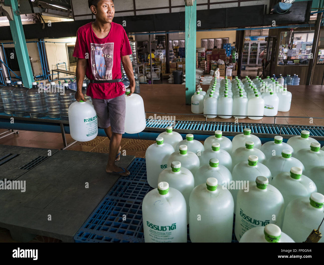 Divieto canzone, Prachin Buri, Thailandia. 16 Mar, 2016. Un lavoratore  porta le bottiglie di acqua al di fuori di un'acqua impianto di  imbottigliamento di Ban canzone. L'impianto è stato aperto per 11