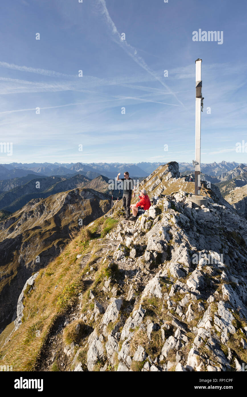 Gli escursionisti sulla vetta del Monte Hochplatte guardare il panorama delle Alpi Ammergau e Tirolo su una soleggiata giornata autunnale Foto Stock