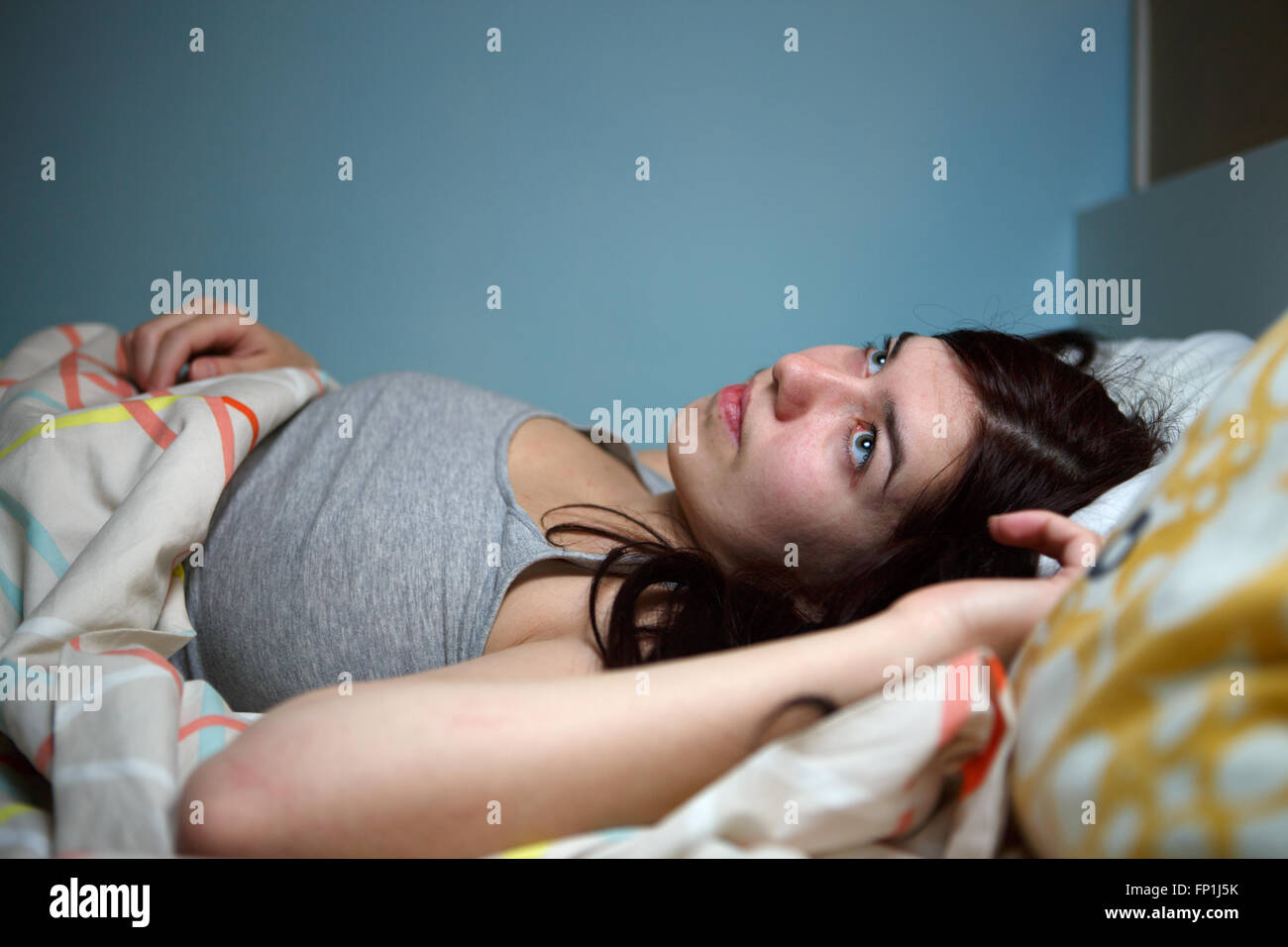 Giovane donna giaceva a letto la sofferenza con insonnia vicino rumoroso, lo stress e il suono della sveglia, impediscono il concetto del sonno Foto Stock