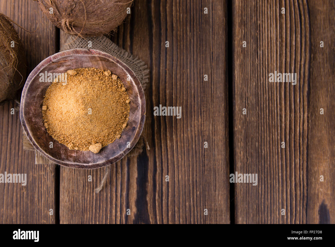 Lo zucchero di cocco (messa a fuoco selettiva) sull'annata sullo sfondo di legno Foto Stock