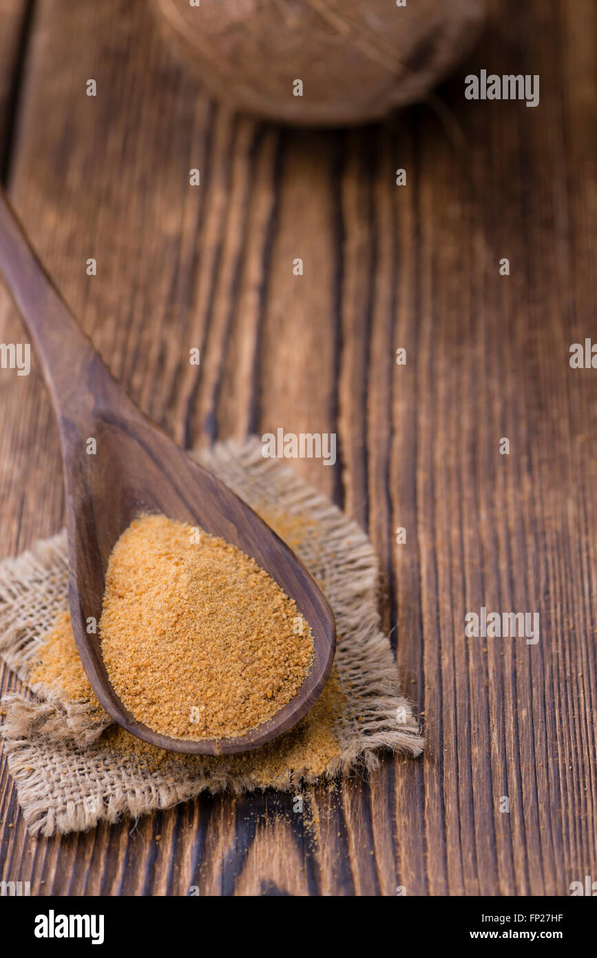 Lo zucchero di cocco (messa a fuoco selettiva) sull'annata sullo sfondo di legno Foto Stock