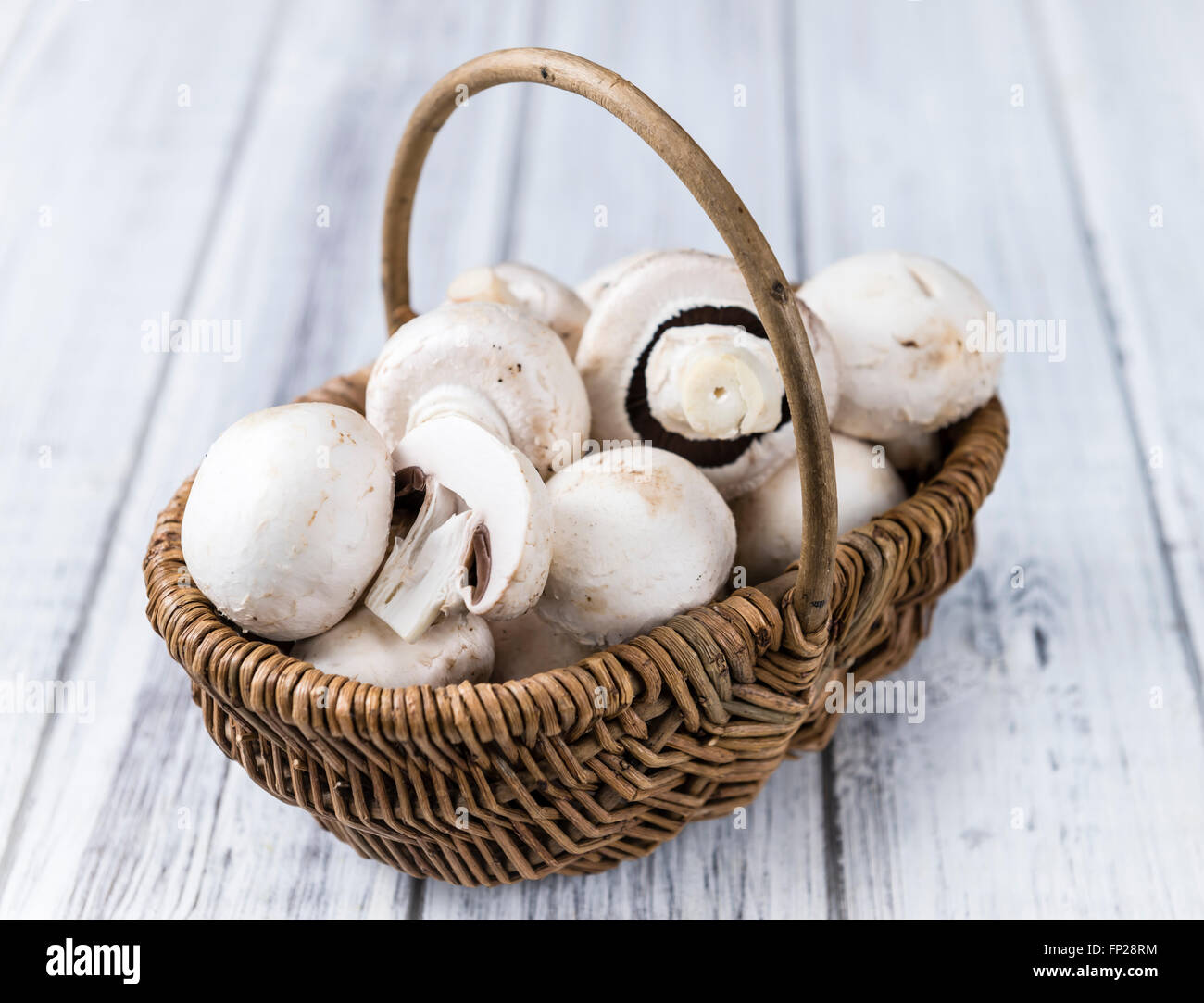 Porzione di bianco fresco di funghi (messa a fuoco selettiva) su sfondo di legno Foto Stock