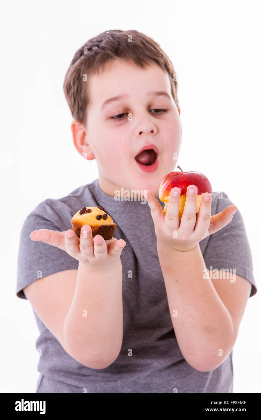 Little Boy con cibi isolati su sfondo bianco - Apple o un muffin Foto Stock