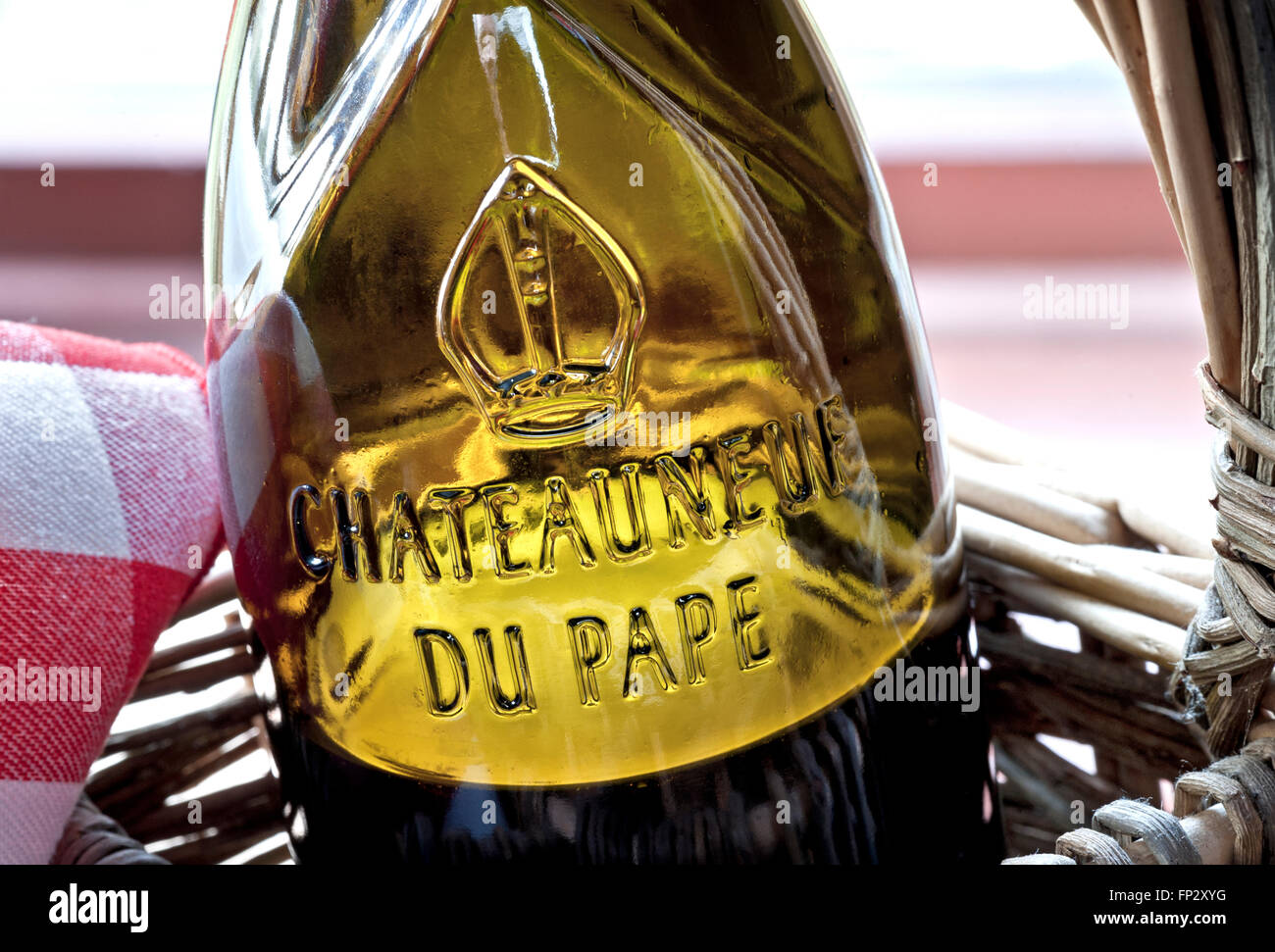 Chiudere la vista sul rilievo di vetro nome etichetta sulla bottiglia di Chateauneuf-du-Pape vino rosso in stile rustico cesto in vimini regione Vaucluse Francia Foto Stock