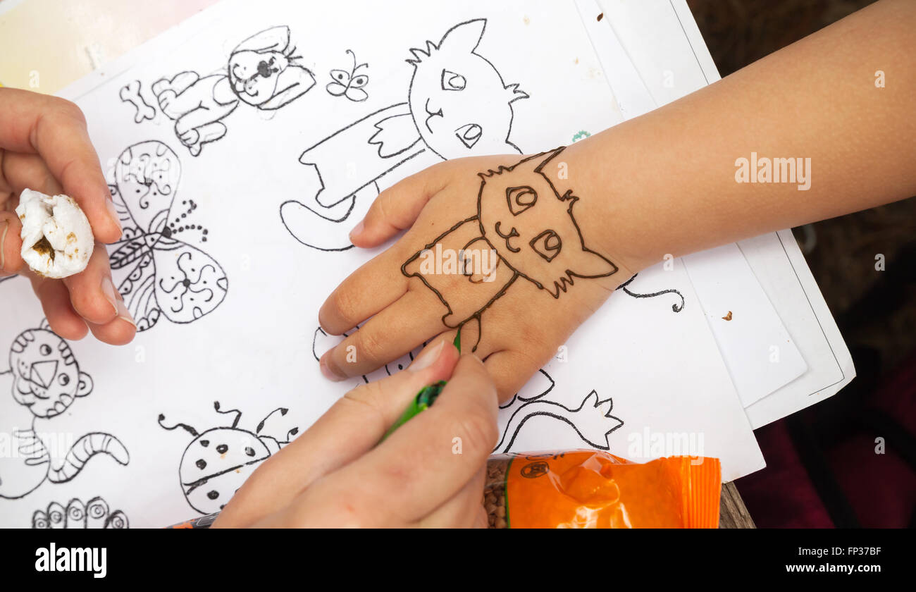 San Pietroburgo, Russia - Luglio 19, 2015: pasta di hennè Applicazione sulla mano del bambino. Indiana tradizionale arredamento di pelle Foto Stock